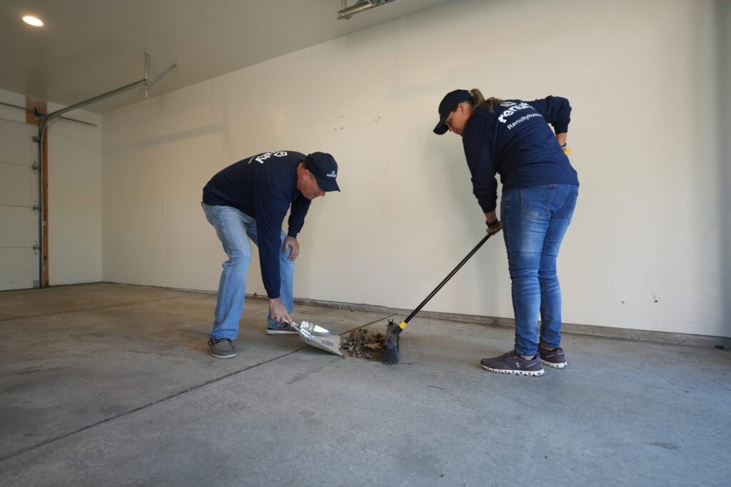 Two Renuity employees cleaning a garage