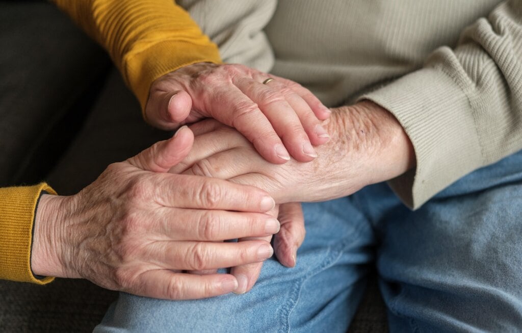 elderly couple holding hands