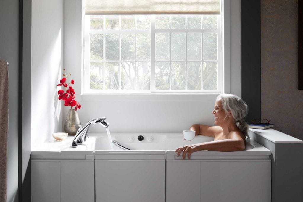 woman smiling in Kohler walk-in bath