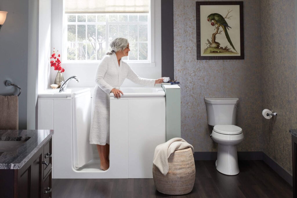 elderly woman standing in a walk-in bath|elderly woman entering a walk-in bath